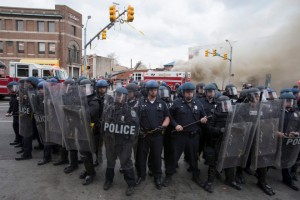 Police form a line in front of a building on fire during protests of the death of Freddie Gray in Baltimore, Maryland (Photo: EPA / Michael Reynolds)