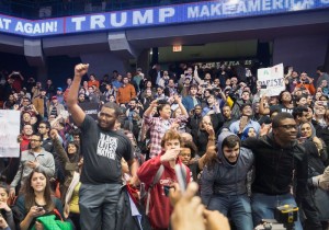 The protester in the front left of this photo is wearing a Black Lives Matter shirt; the poster in the far right is a reference to Trump's comments about immigrants being rapists. Credit:Scott Olson/Getty