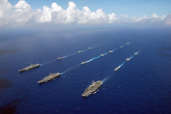 060618-N-8492C-221 Philippine Sea (June 18, 2006) - The Kitty Hawk, Ronald Reagan and Abraham Lincoln Carrier Strike groups sail in formation, as Air Force, Navy and Marine Corps aircraft fly overhead during the photo portion of Exercise Valiant Shield 2006. Valiant Shield focuses on integrated joint training among U.S. military forces, enabling real-world proficiency in sustaining joint forces and in detecting, locating, tracking and engaging units at sea, in the air, on land and cyberspace in response to a range of mission areas. U.S. Navy photo by Chief Photographer's Mate Todd P. Cichonowicz (RELEASED)