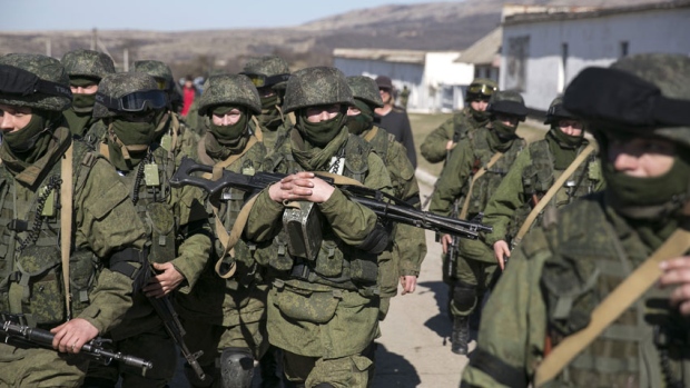 Military personnel, believed to be Russian servicemen, walk outside the territory of a Ukrainian military unit in Crimea. A Ukrainian mission to the United Nations claims 16,000 Russian troops have massed in Crimea. (Baz Ratner/Reuters)
