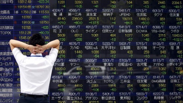 Man looks at a stock quotation board outside a brokerage in Tokyo