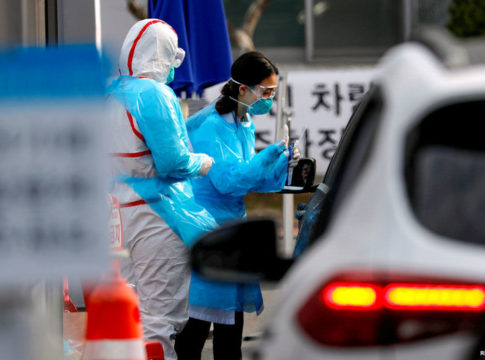 A medical staff member in protective gear prepares to take samples from a visitor in a car at a 'drive-thru' testing center for the novel coronavirus disease of COVID-19 in Yeungnam University Medical Center in Daegu, South Korea, March 3, 2020. REUTERS/Kim Kyung-Hoon - RC28CF933C88
