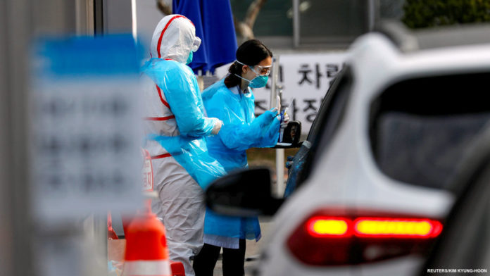 A medical staff member in protective gear prepares to take samples from a visitor in a car at a 'drive-thru' testing center for the novel coronavirus disease of COVID-19 in Yeungnam University Medical Center in Daegu A medical staff member in protective gear prepares to take samples from a visitor in a car at a 'drive-thru' testing center for the novel coronavirus disease of COVID-19 in Yeungnam University Medical Center in Daegu, South Korea, March 3, 2020. REUTERS/Kim Kyung-Hoon - RC28CF933C88