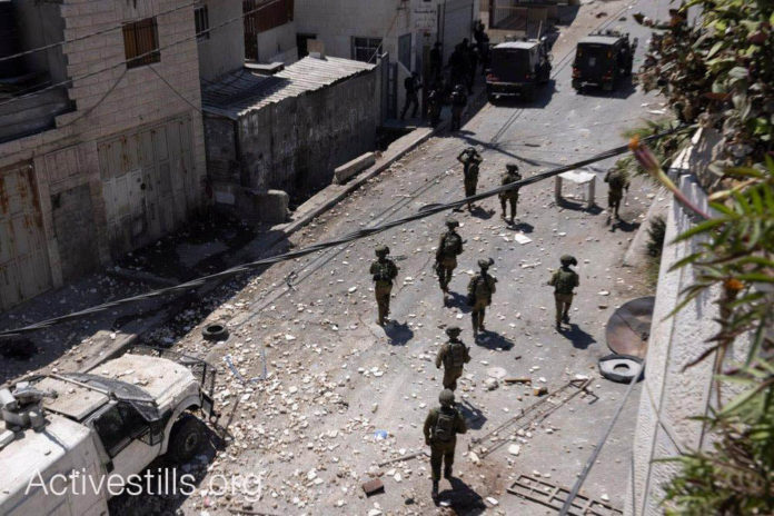 222640462_10158039251307073_9208499566642651991_n An Israeli military force during the funeral of Mohammed al-‘Alami, 12, in the village of Beit Ummar, Photo: Oren Ziv / Activestills