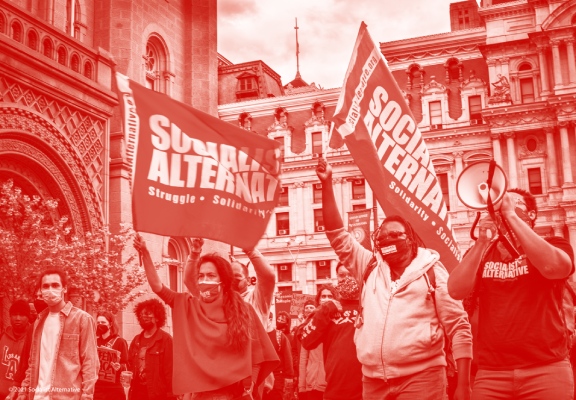 Socialist Alternative activists with megaphone and flags marching in the streets